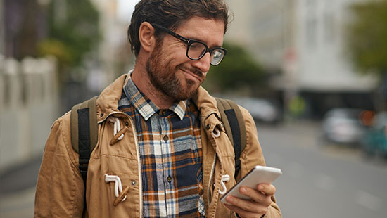 Man looking suspiciously at his phone at a phishing attempt