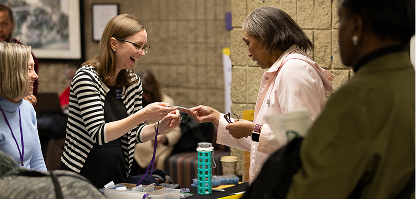 Abby Rosensweig, Learning Technologist in Teaching and Learning Technologies, greets the TEACHx crowd while finding attendees' name badges.