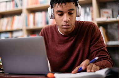 Image of student wearing headphones in library