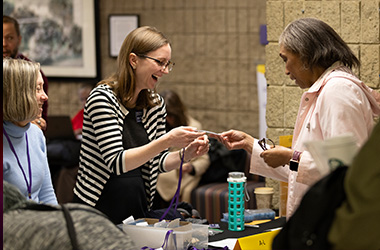 Abby Rosensweig, Learning Technologist in Teaching and Learning Technologies, greets the TEACHx crowd while finding attendees' name badges.