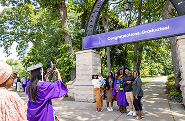 Graduating student in front of arch