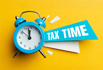 Alarm clock and colour papers on the white background. Tax Time.