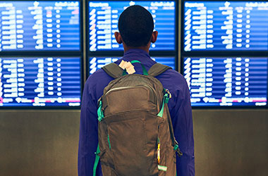 person standing in front of an airport flight schedule