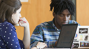 Students in University Library working on laptops