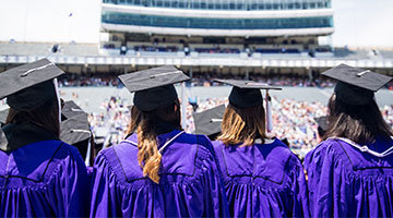 Graduates on Ryan Field in cap and gowns